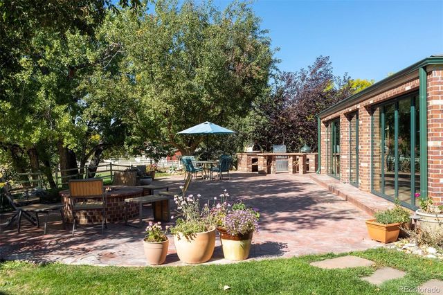a view of a patio with table and chairs potted plants and large tree