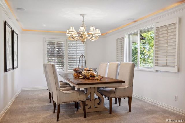 a dining room with furniture a chandelier and window