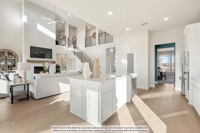 a large white kitchen with lots of counter space a sink and a large window