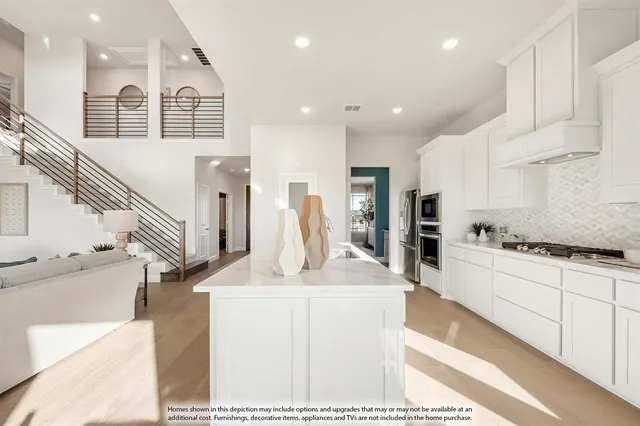 a kitchen with stainless steel appliances kitchen island granite countertop a stove a sink and a refrigerator