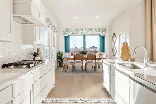 a kitchen with stainless steel appliances granite countertop a stove a sink a dining table and chairs with white countertops