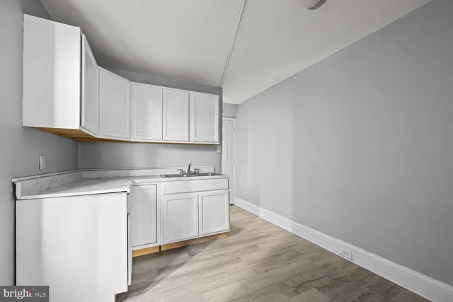 a kitchen with stainless steel appliances granite countertop a sink and cabinets with wooden floor