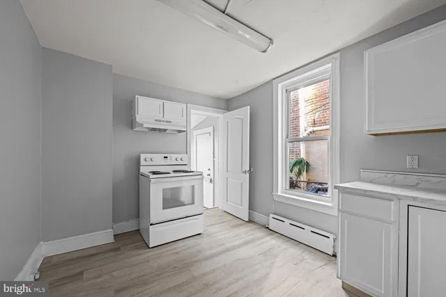 a kitchen with a stove a sink and a window