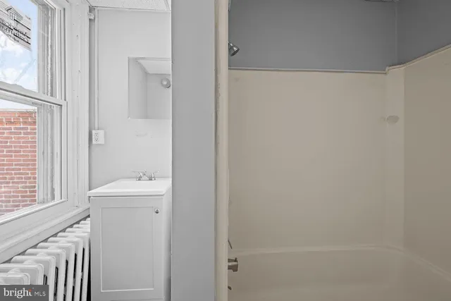 a bathroom with a sink a toilet and a window