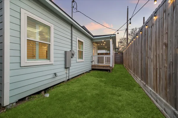 a view of a house with backyard and wooden fence