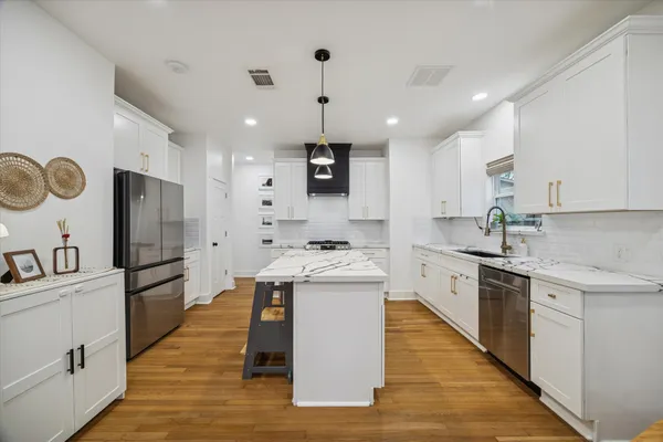 a kitchen with stainless steel appliances granite countertop a sink stove and refrigerator