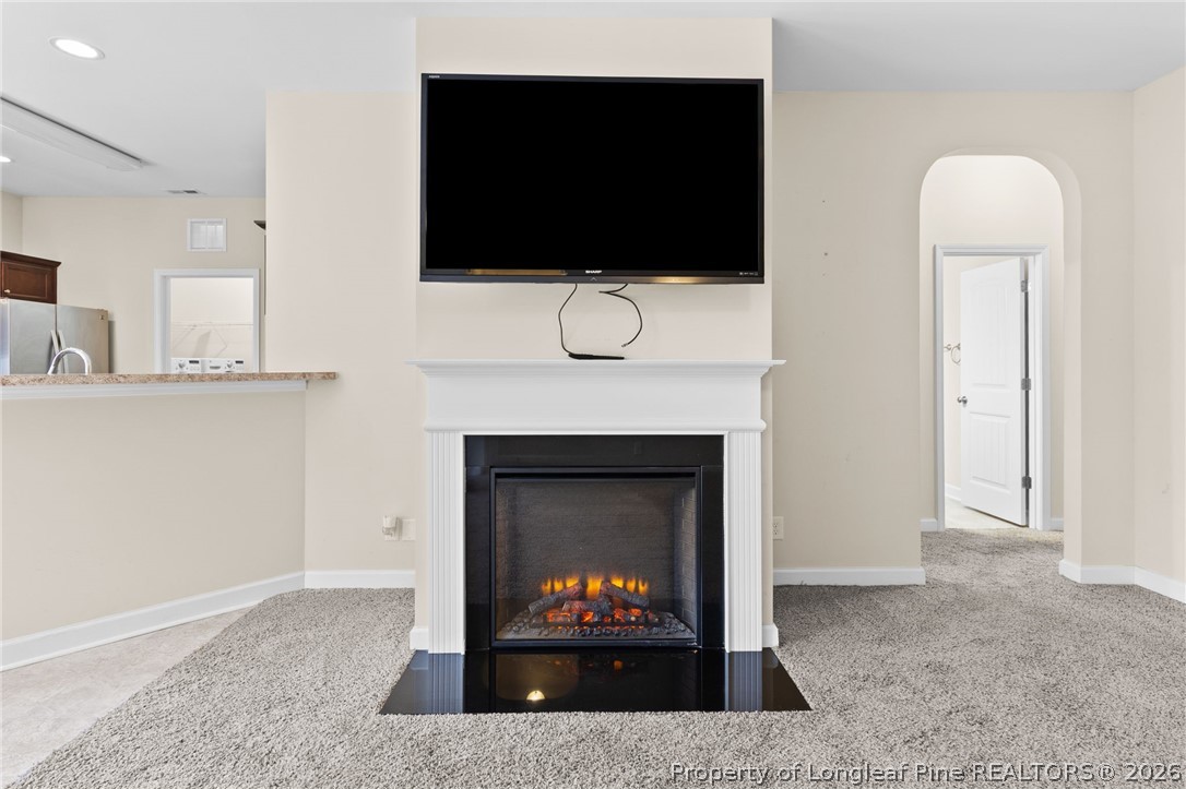 216 Meherrin Loop Raeford, NC 28376 - Photo 7 of 38 a living room with a fireplace a flat screen tv and a sink