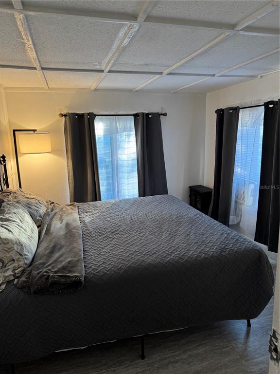 7289 Toucan Trail Spring Hill, FL 34606 - Photo 21 of 27 a bedroom with a bed and wooden floor