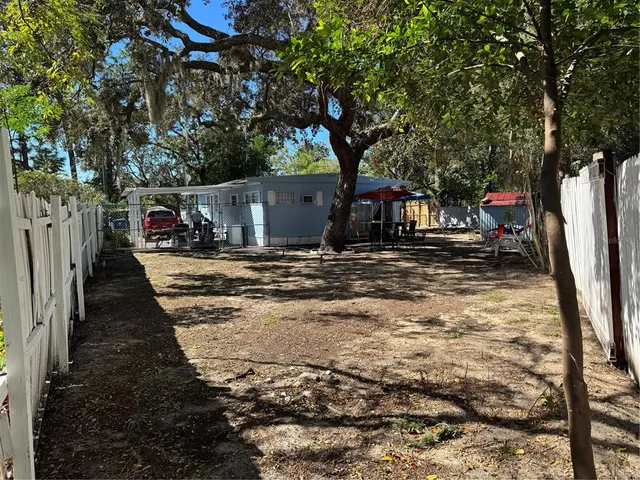 a view of a yard with wooden fence