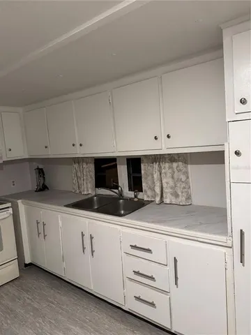a kitchen with white cabinets and white appliances