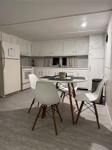 a kitchen with stainless steel appliances a table chairs and a refrigerator