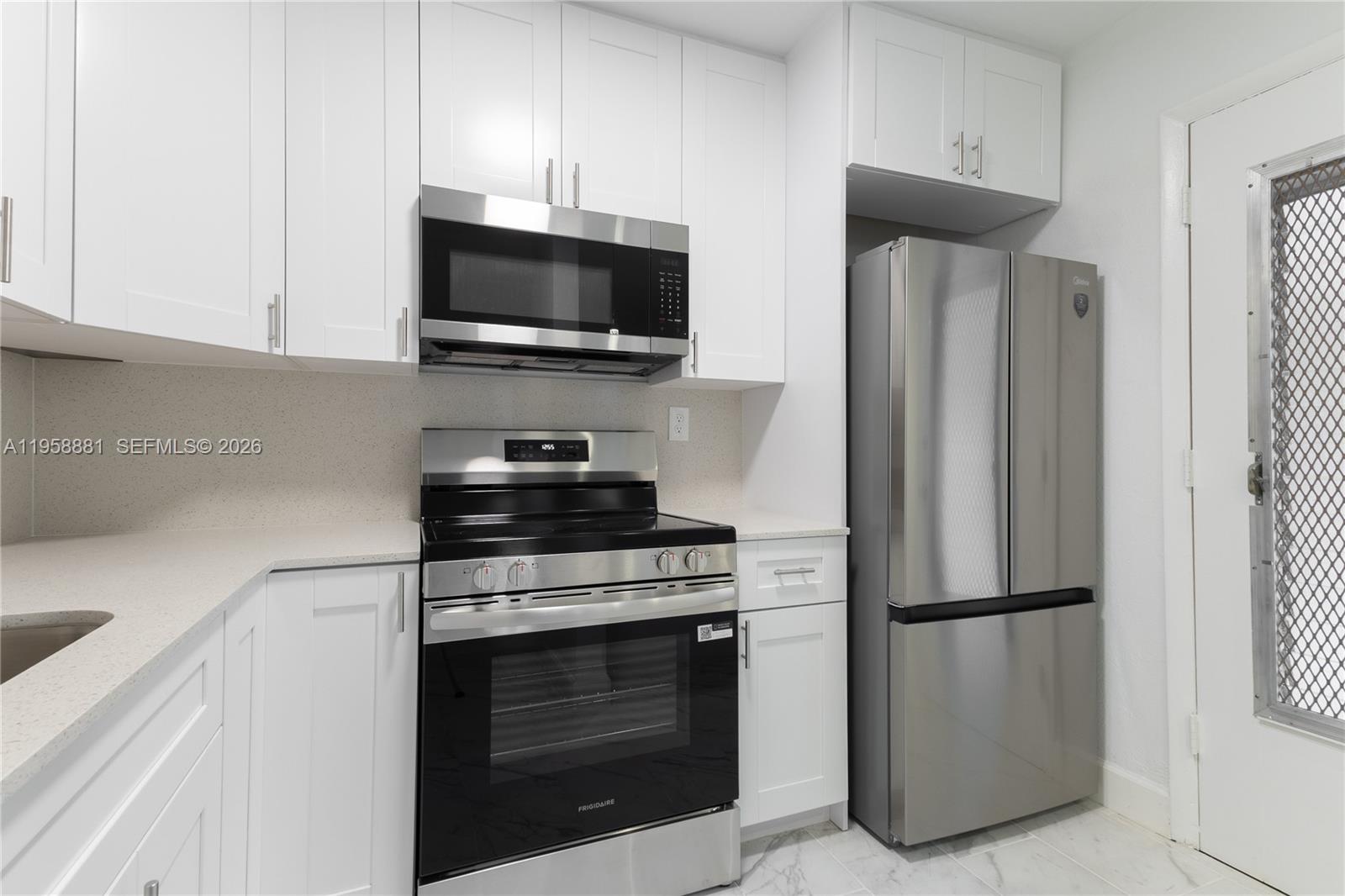 5301 Southwest 77th Court, Unit 201G Miami, FL 33155 - Photo 6 of 17 a kitchen with stainless steel appliances a refrigerator stove and microwave