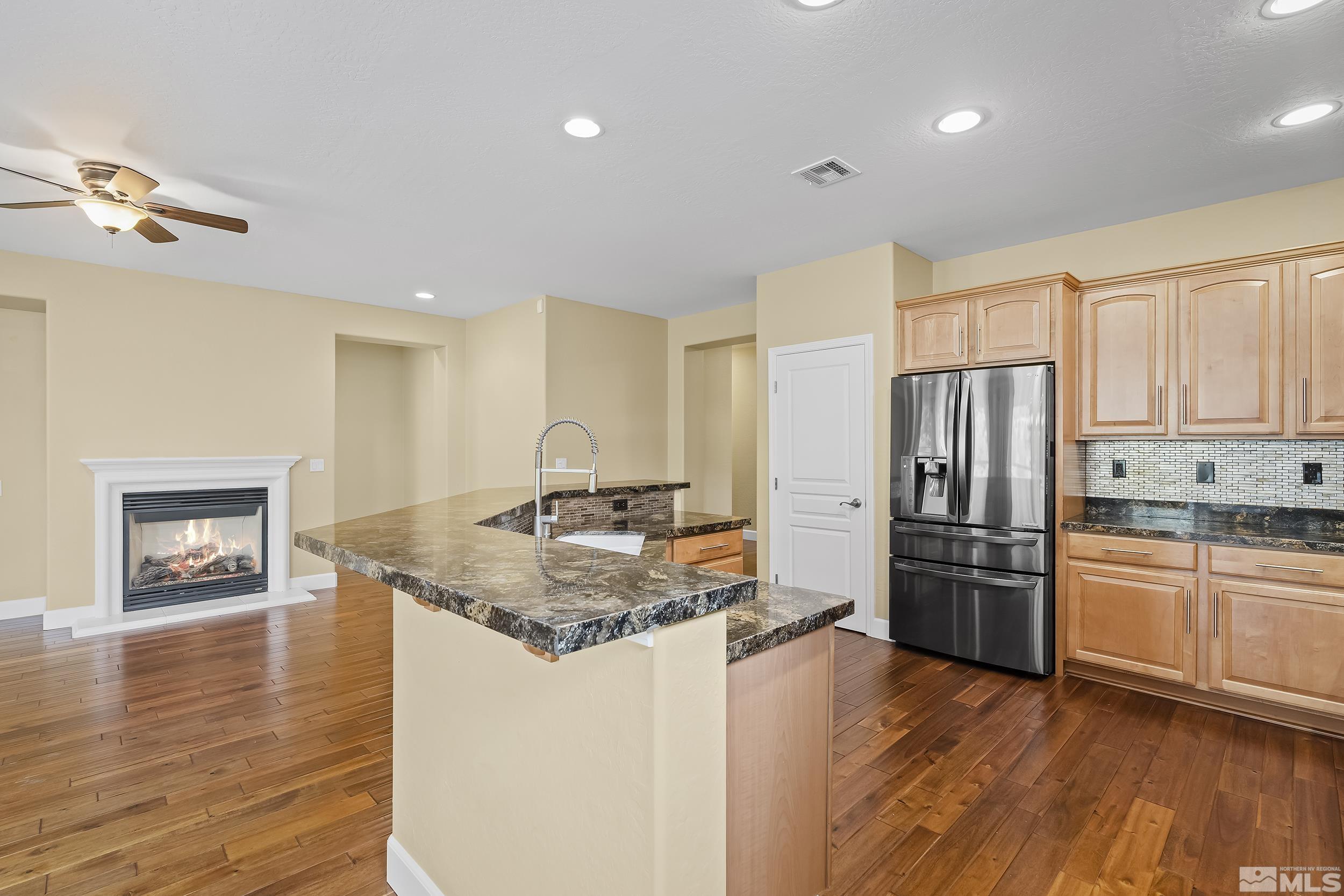 1745 Trail Creek Way Reno, NV 89523 - Photo 13 of 28 a kitchen with stainless steel appliances granite countertop a refrigerator a stove and a wooden floors
