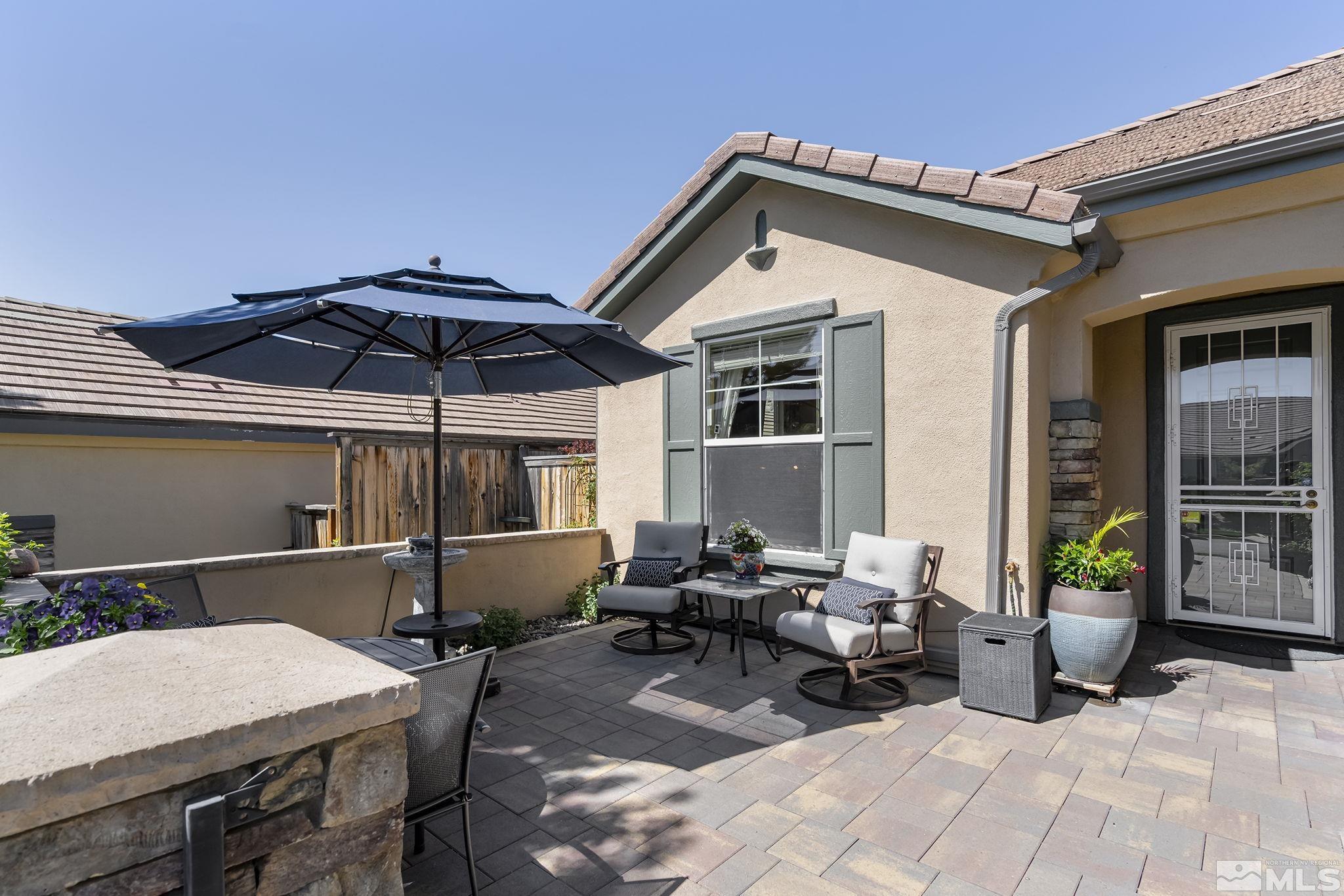 1745 Trail Creek Way Reno, NV 89523 - Photo 26 of 28 a patio with a table and chairs under an umbrella