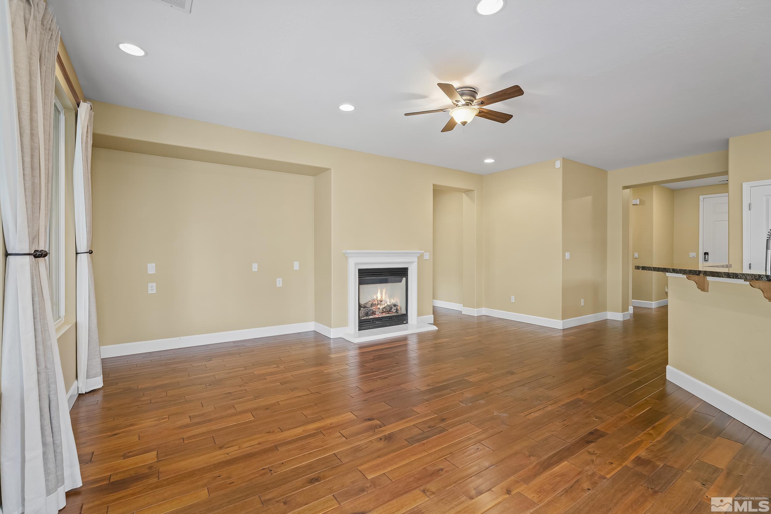 1745 Trail Creek Way Reno, NV 89523 - Photo 9 of 28 a view of an empty room with wooden floor and a ceiling fan
