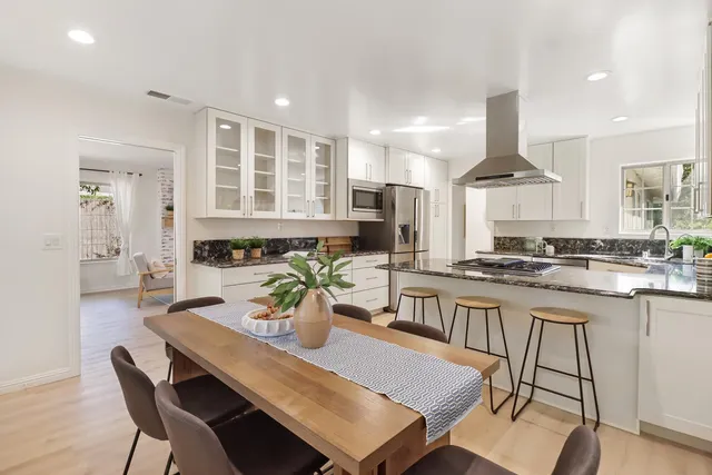 a kitchen with stainless steel appliances kitchen island granite countertop a sink stove and refrigerator
