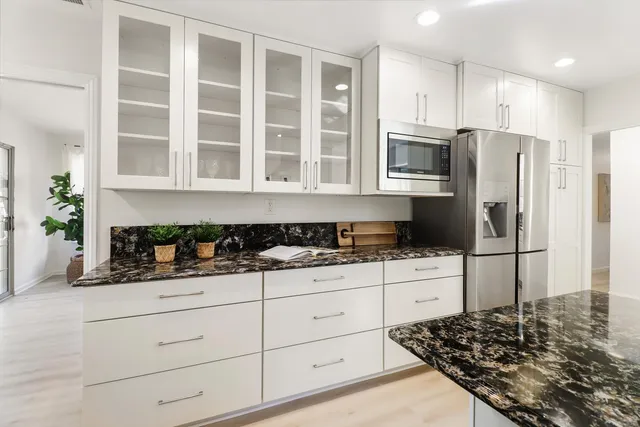 a kitchen with granite countertop a sink a stove and cabinets