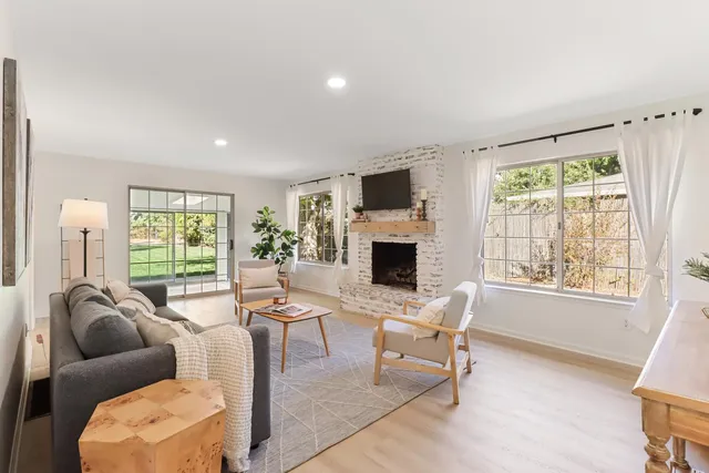 a living room with furniture a fireplace and a flat screen tv