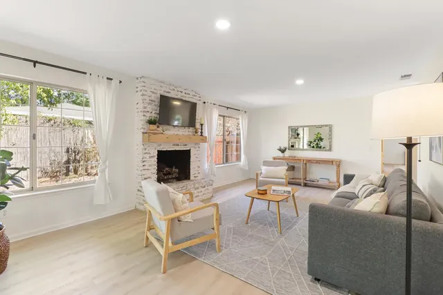a living room with furniture a fireplace and a flat screen tv