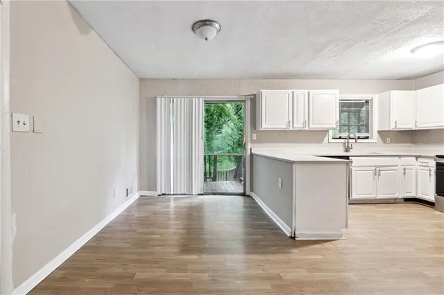 a kitchen with wooden floors and white walls