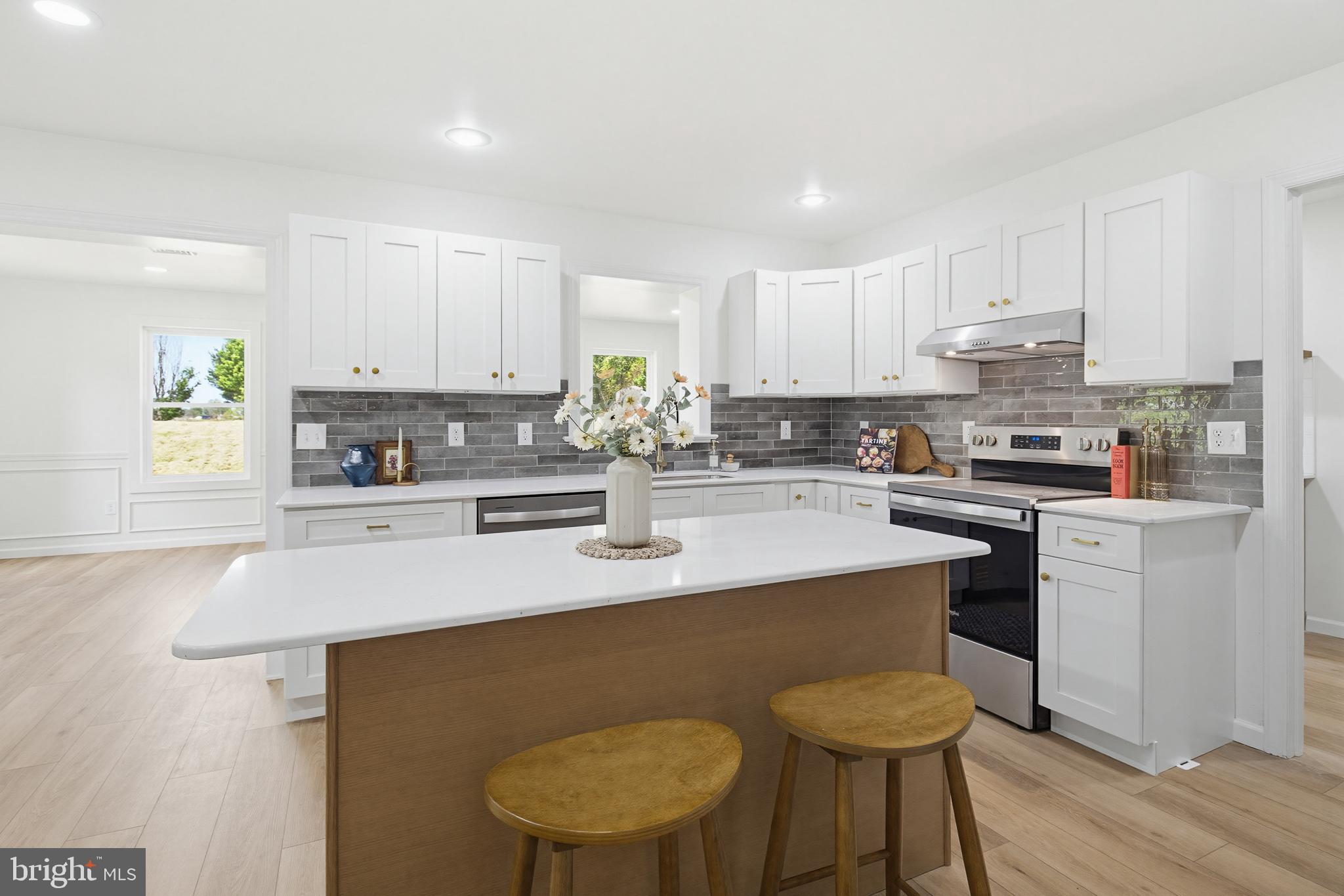 112 Sawmill Road Elizabethtown, PA 17022 - Photo 12 of 56 a kitchen with stainless steel appliances granite countertop a sink a stove a refrigerator a microwave and white cabinets with wooden floor