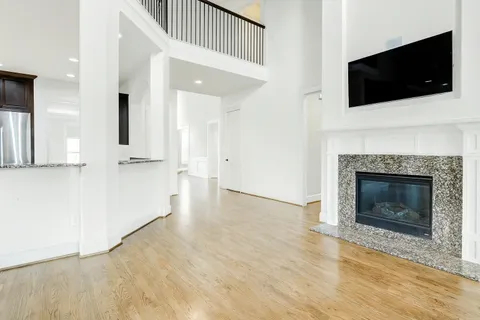 a view of a livingroom with a fireplace a flat screen tv and staircase