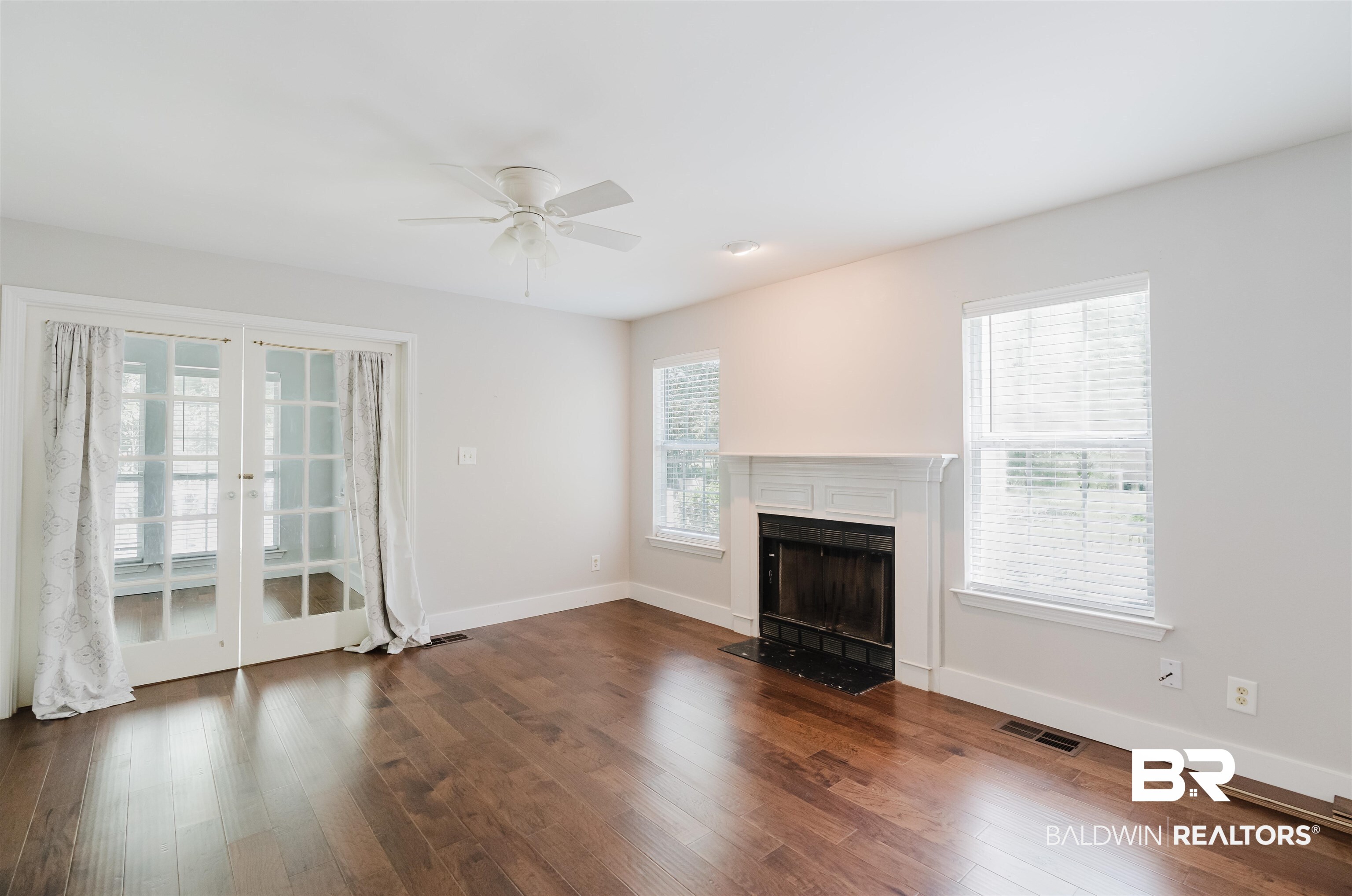 20460 Bishop Road Fairhope, AL 36532 - Photo 14 of 41 Unfurnished living room with a fireplace with flush hearth, a ceiling fan, baseboards, and dark wood-type flooring