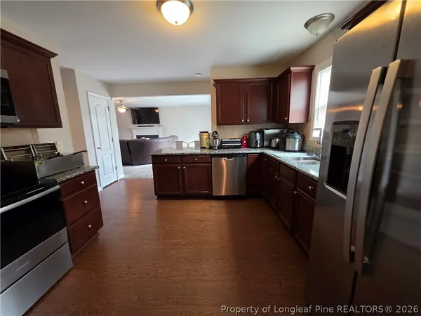 a large kitchen with a stove a sink dishwasher and a refrigerator