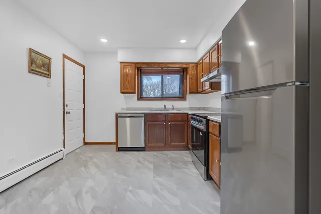 a kitchen with stainless steel appliances granite countertop a refrigerator and a sink