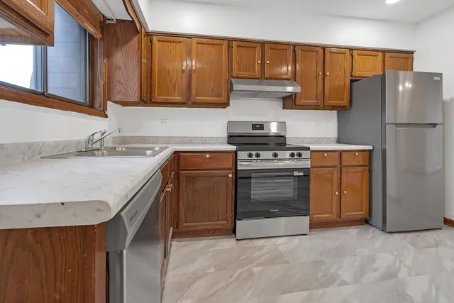 a kitchen with a stove sink and refrigerator