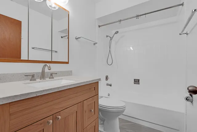 a bathroom with a granite countertop sink toilet and shower