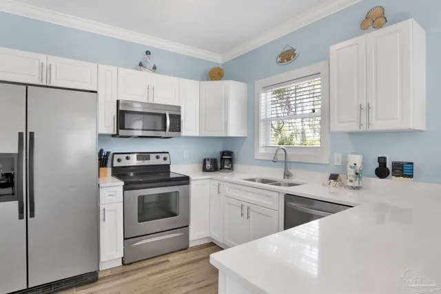 a kitchen with stainless steel appliances a stove a sink a stove a microwave and cabinets