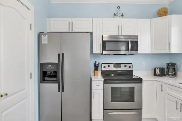 a kitchen with cabinets stainless steel appliances and a counter space