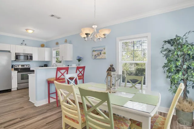 a view of a dining room with furniture a chandelier and wooden floor