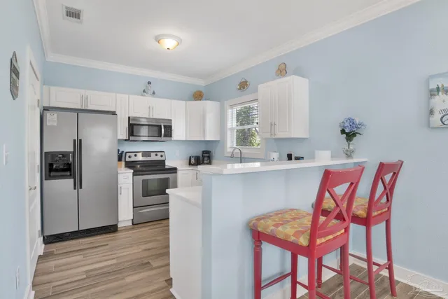 a kitchen with stainless steel appliances cabinets a microwave and a wooden floor