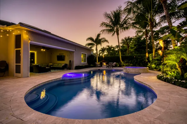 a view of a swimming pool with lawn chairs under an umbrella