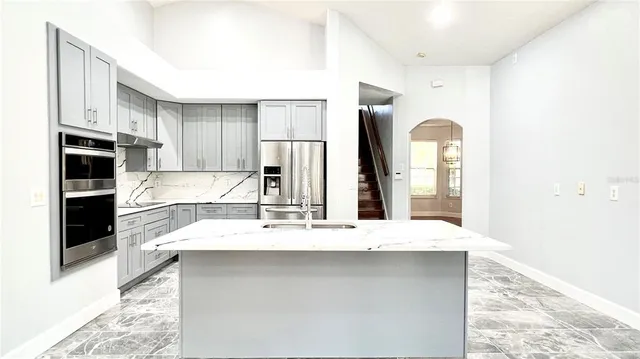 a kitchen with granite countertop a refrigerator and a sink