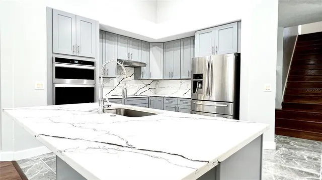 a kitchen with granite countertop white cabinets and white appliances