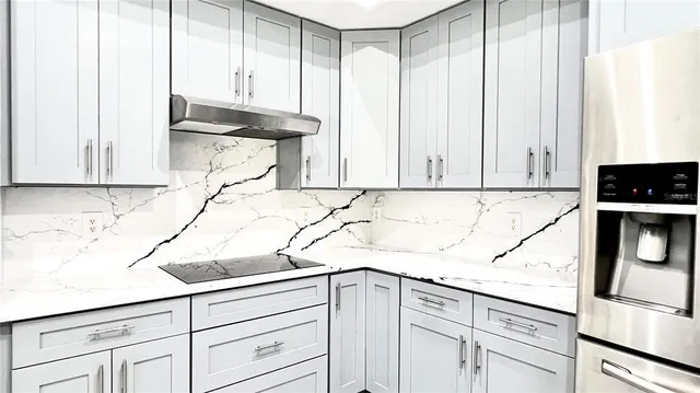 a kitchen with a sink and a stove top oven with wooden floor