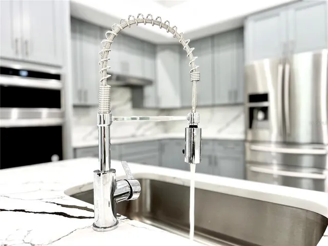 a kitchen with stainless steel appliances kitchen island a sink refrigerator and cabinets