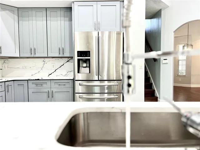 a kitchen with stainless steel appliances kitchen island granite countertop a sink and a window