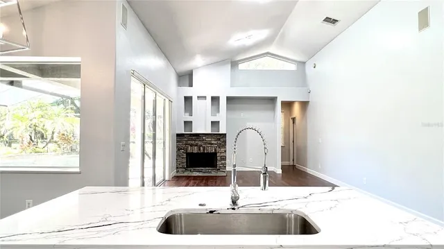 a bedroom with wooden floor fireplace and windows