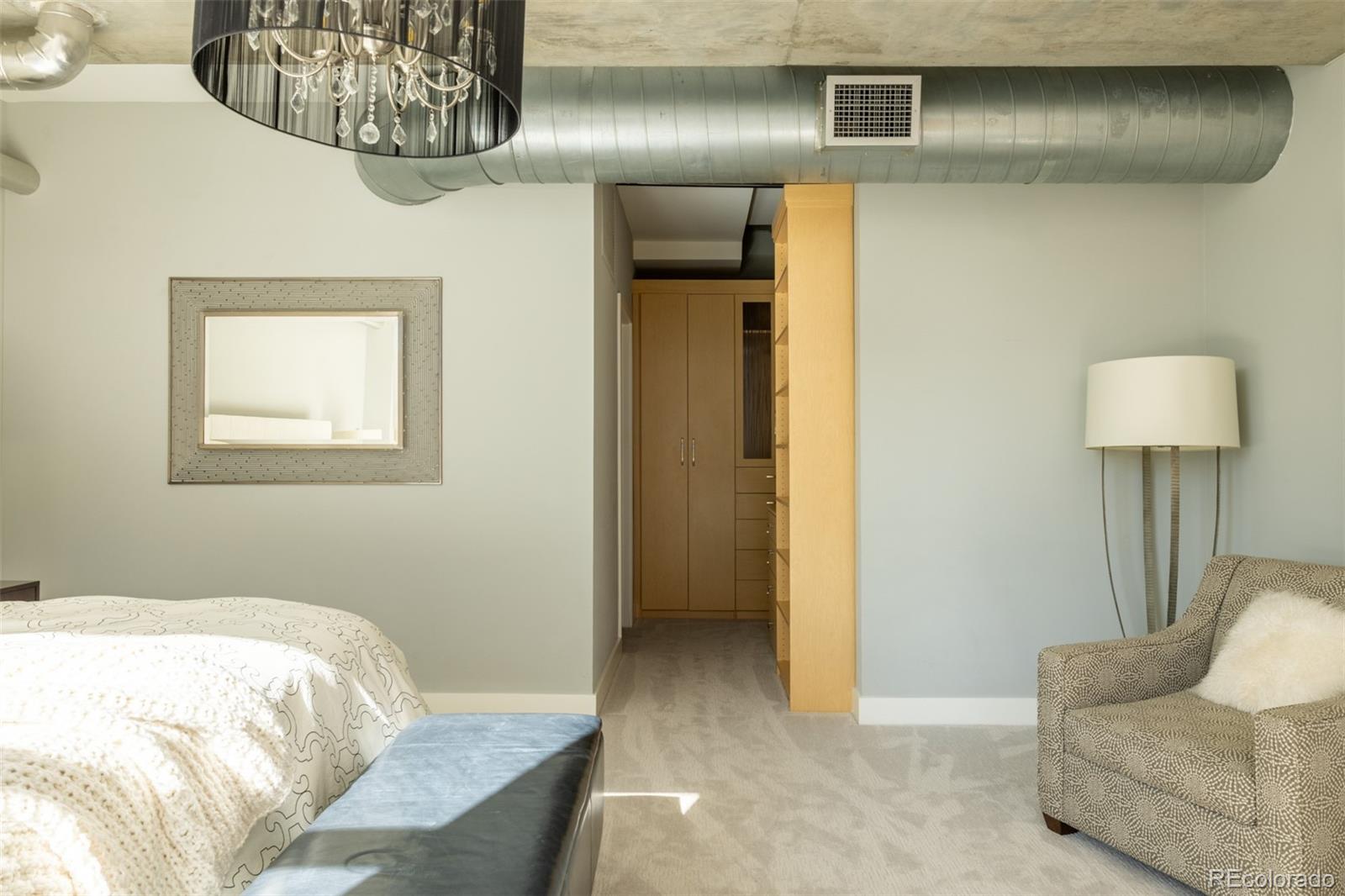 2100 16th St Mall, Unit 607 Denver, CO 80202 - Photo 19 of 46 a bedroom with a bed and chair