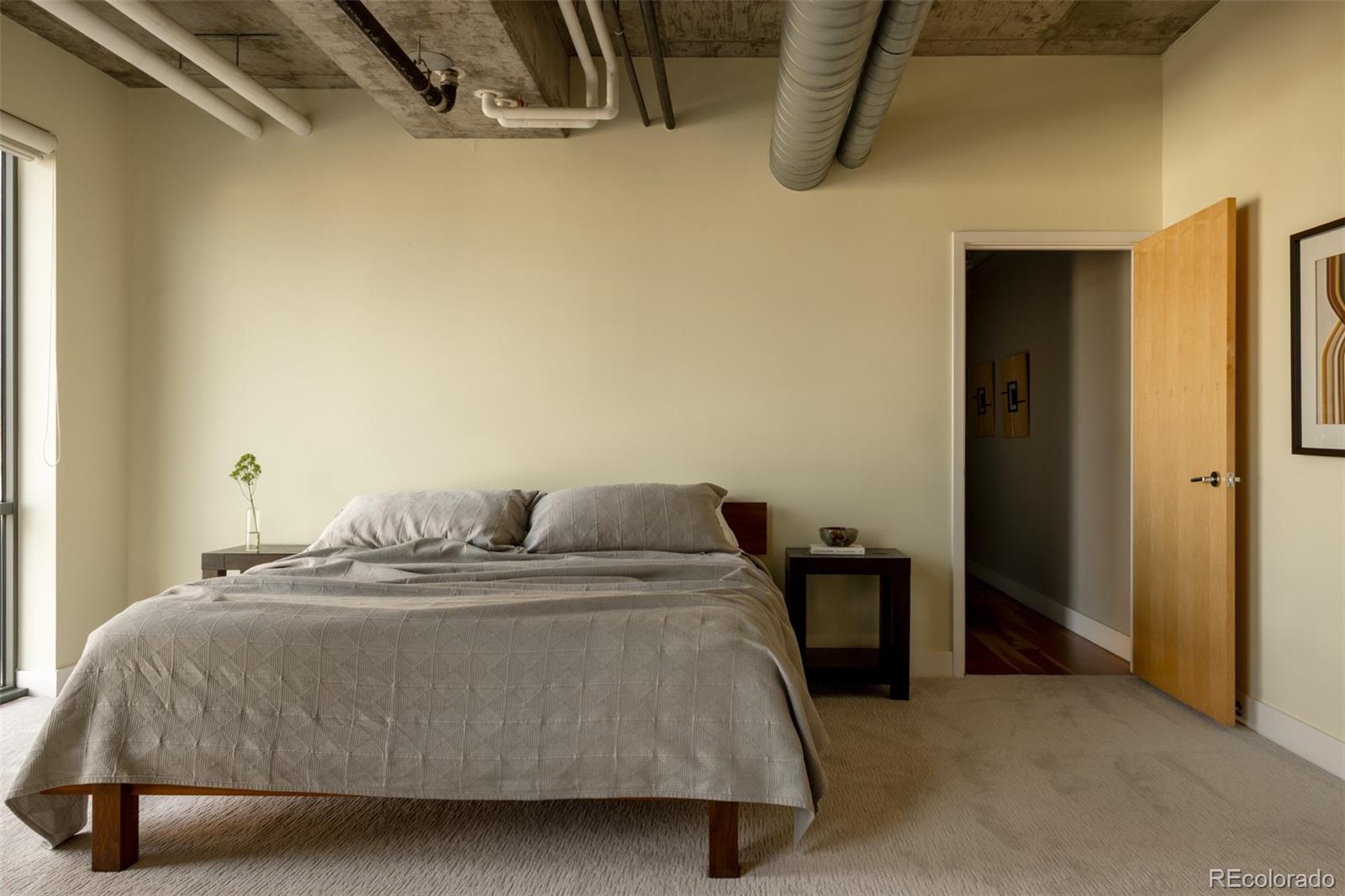 2100 16th St Mall, Unit 607 Denver, CO 80202 - Photo 32 of 46 a bedroom with a bed and dresser