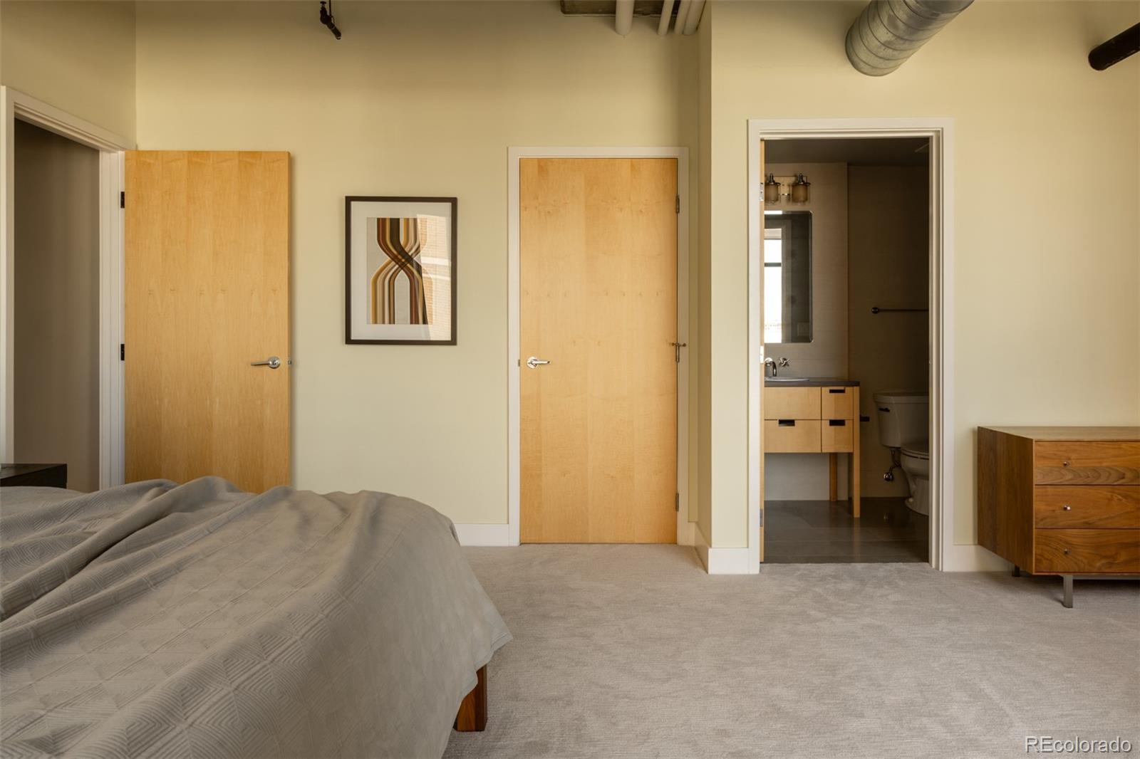 2100 16th St Mall, Unit 607 Denver, CO 80202 - Photo 33 of 46 a bedroom with a bed and a view of bathroom