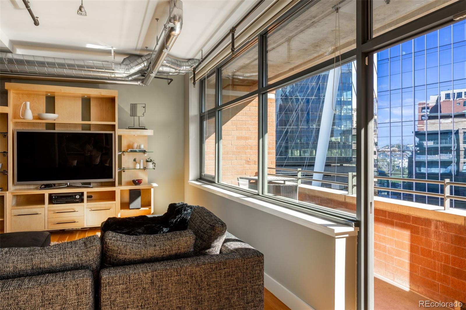 2100 16th St Mall, Unit 607 Denver, CO 80202 - Photo 10 of 46 a living room with furniture tv and a flat screen tv