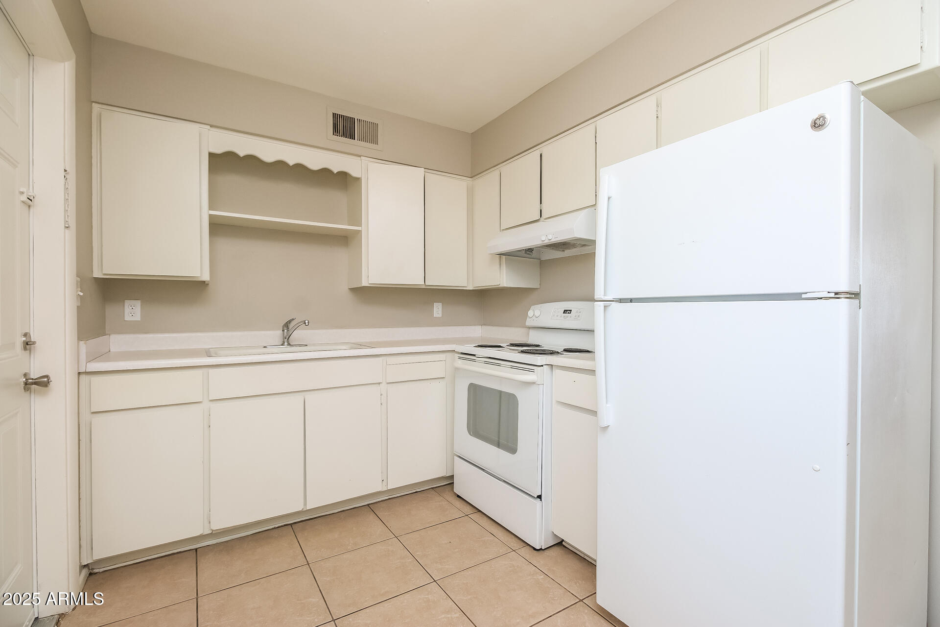 826 East 4th Place, Unit B Mesa, AZ 85203 - Photo 5 of 11 a kitchen with white cabinets and white appliances
