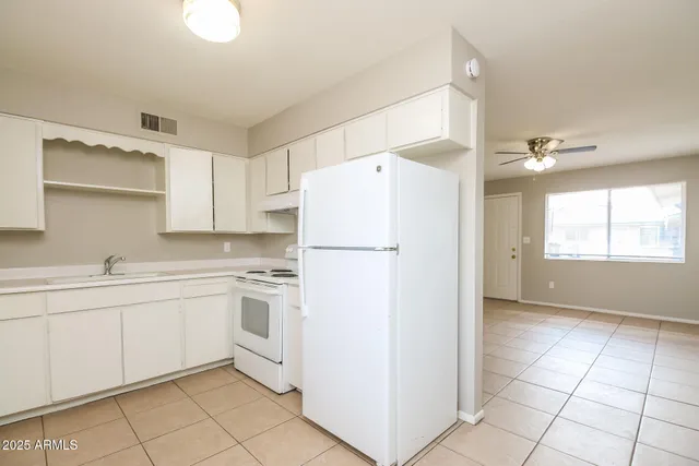 a kitchen with white cabinets and white appliances