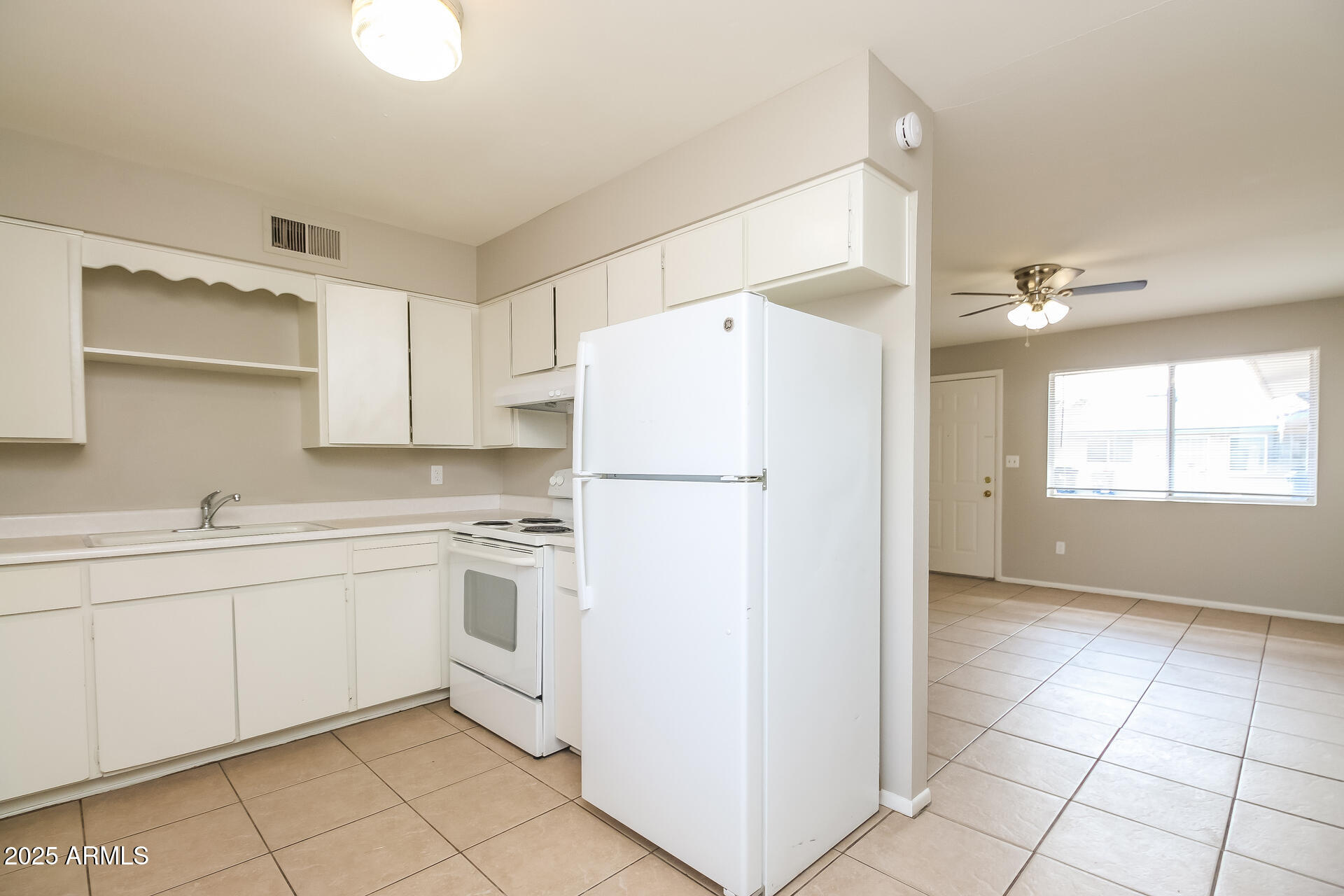 826 East 4th Place, Unit B Mesa, AZ 85203 - Photo 6 of 11 a kitchen with white cabinets and white appliances