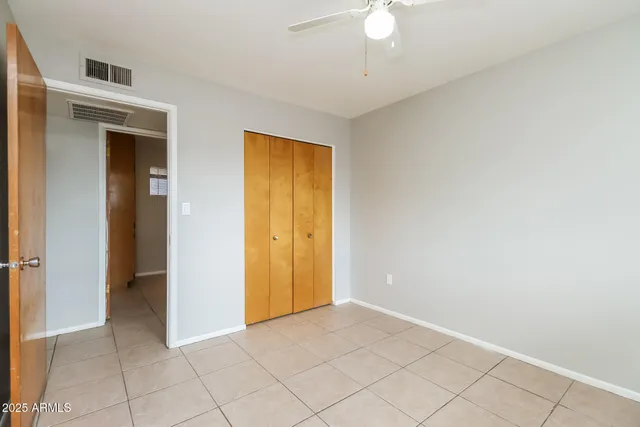 an empty room with a window and a fan